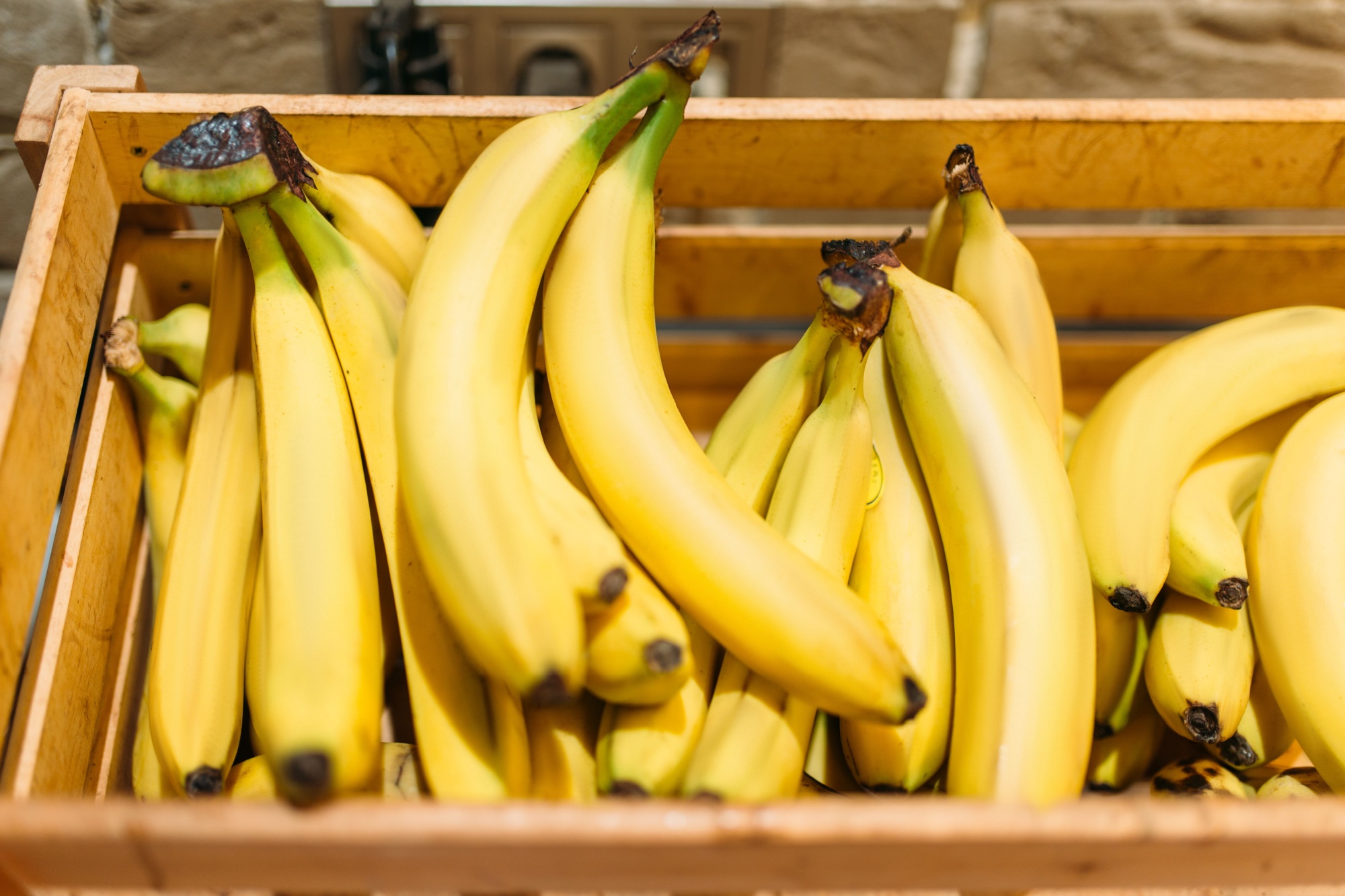 Box with ripe bananas in food store, nobody