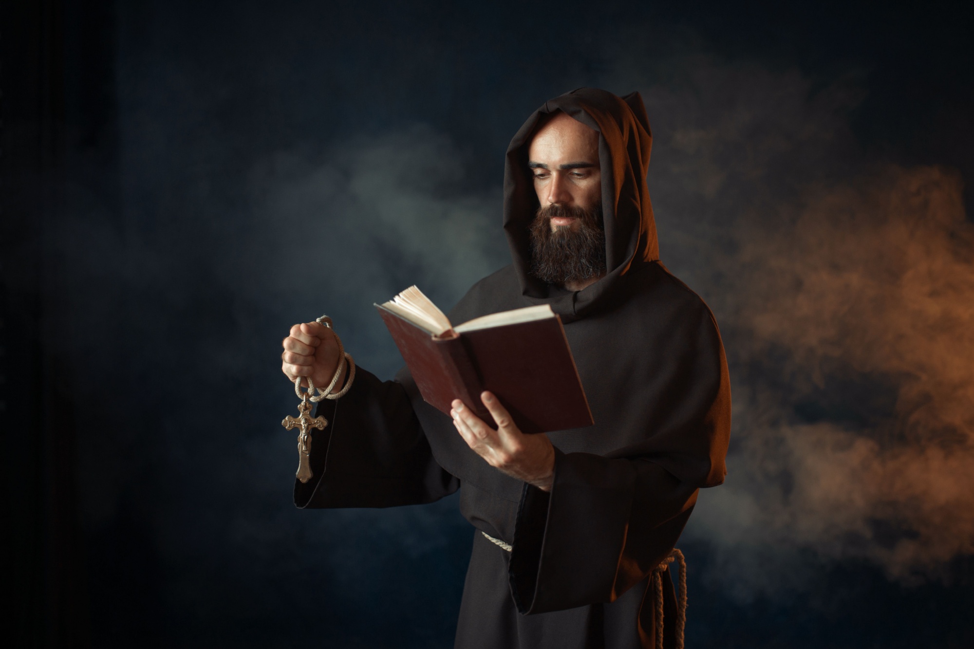 Medieval monk praying with book in church