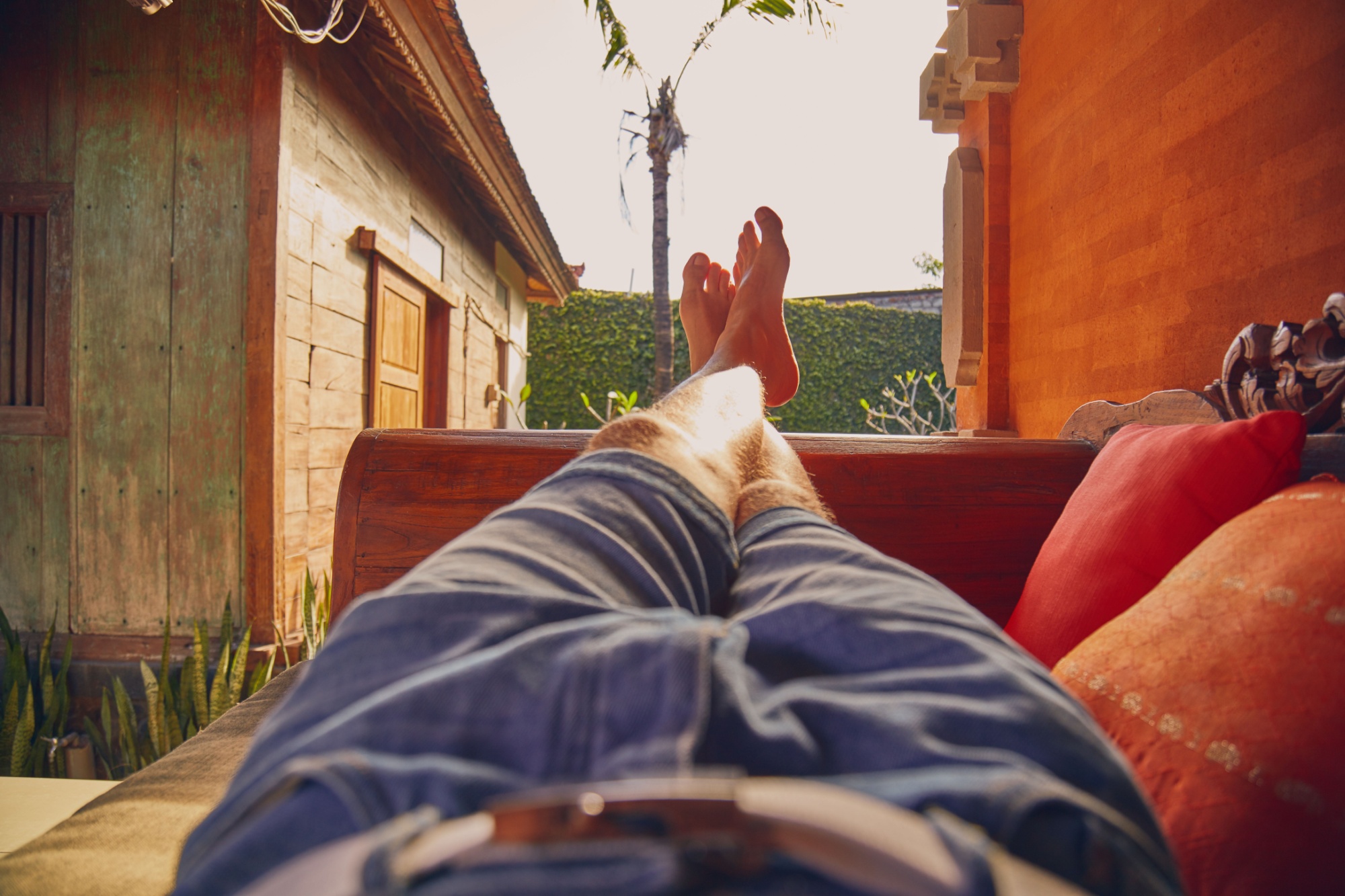 Man's legs on a porch sofa in summertime.