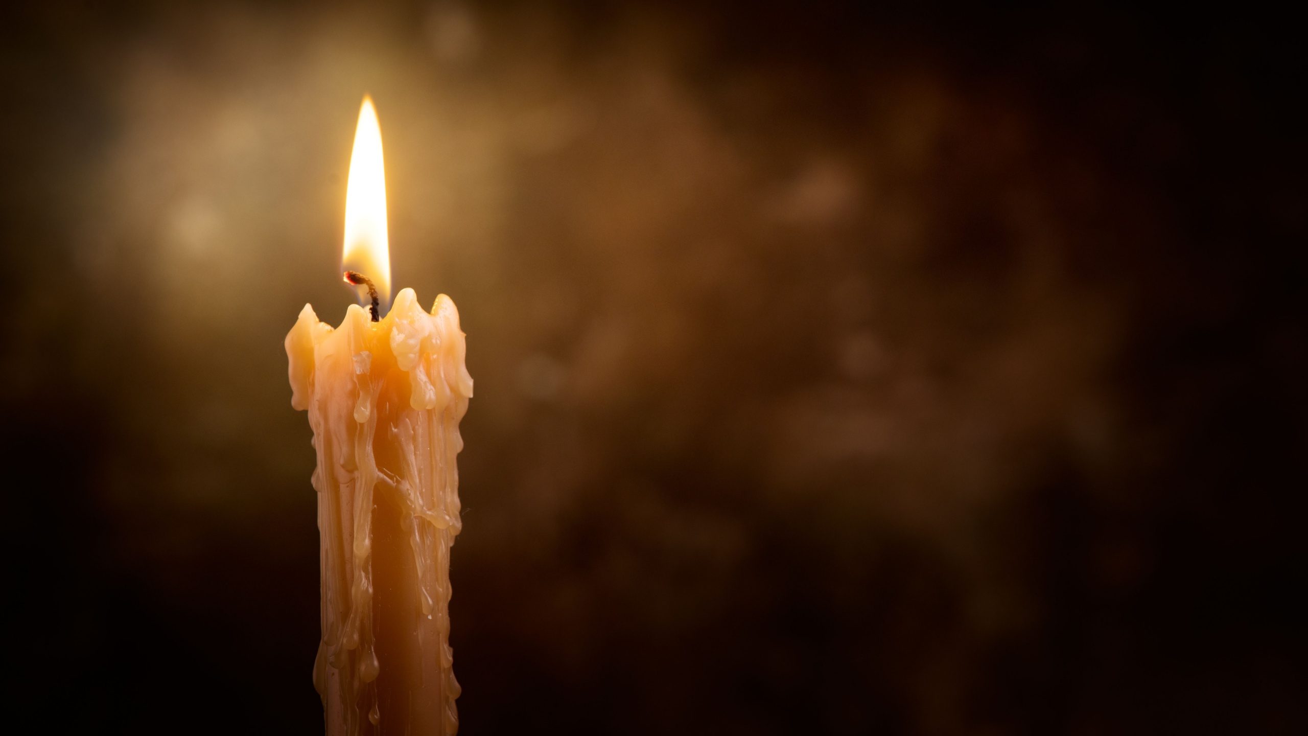 Candle flame close up on a dark background. Melted Wax Candle light border design. Burning at Night, Darkness. Candlelight. Widescreen