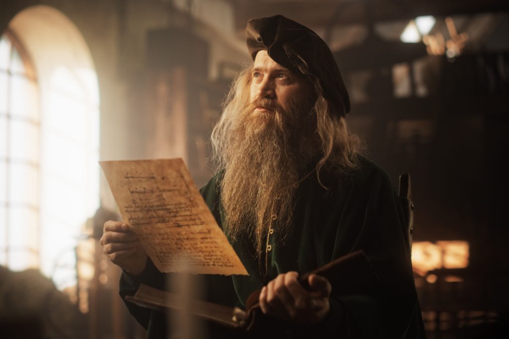 Portrait of an Old Renaissance Male Inventor Reading a Book and Thinking about Ideas of Innovation of the Times. A Curious Librarian Getting Knowledge and Wisdom from History Books