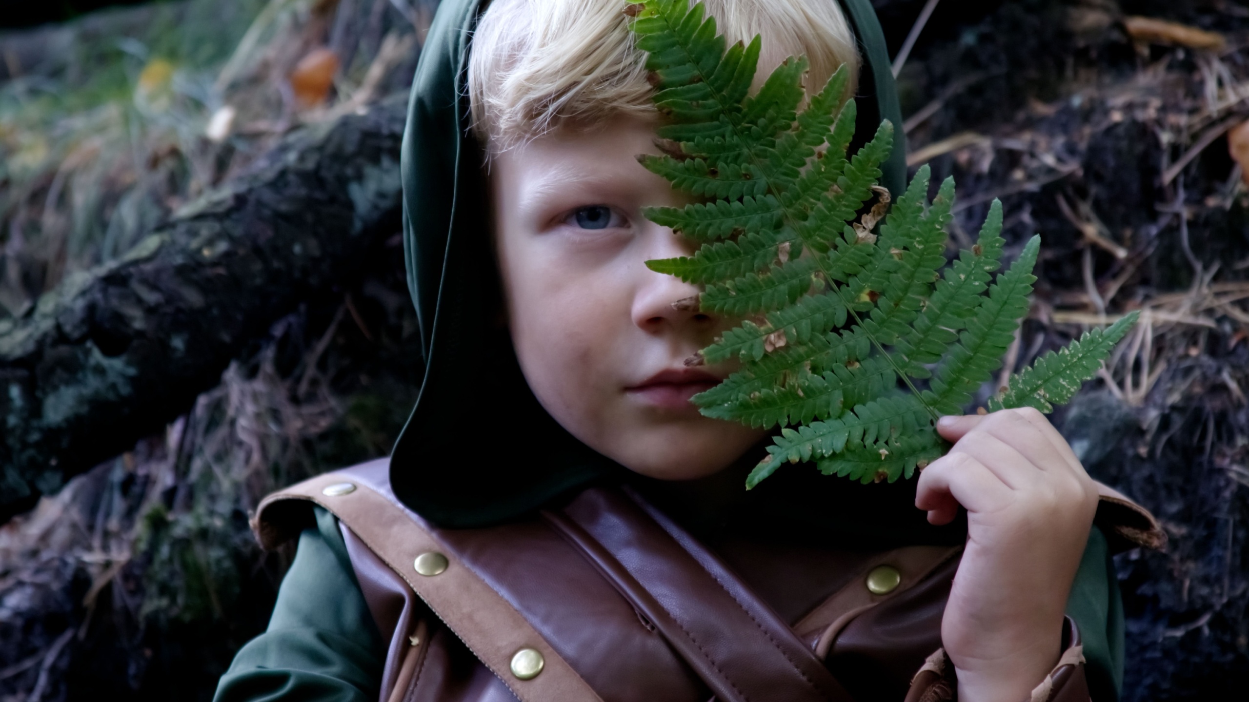 Close up portrait of a boy in a medieval costume against a forest background
