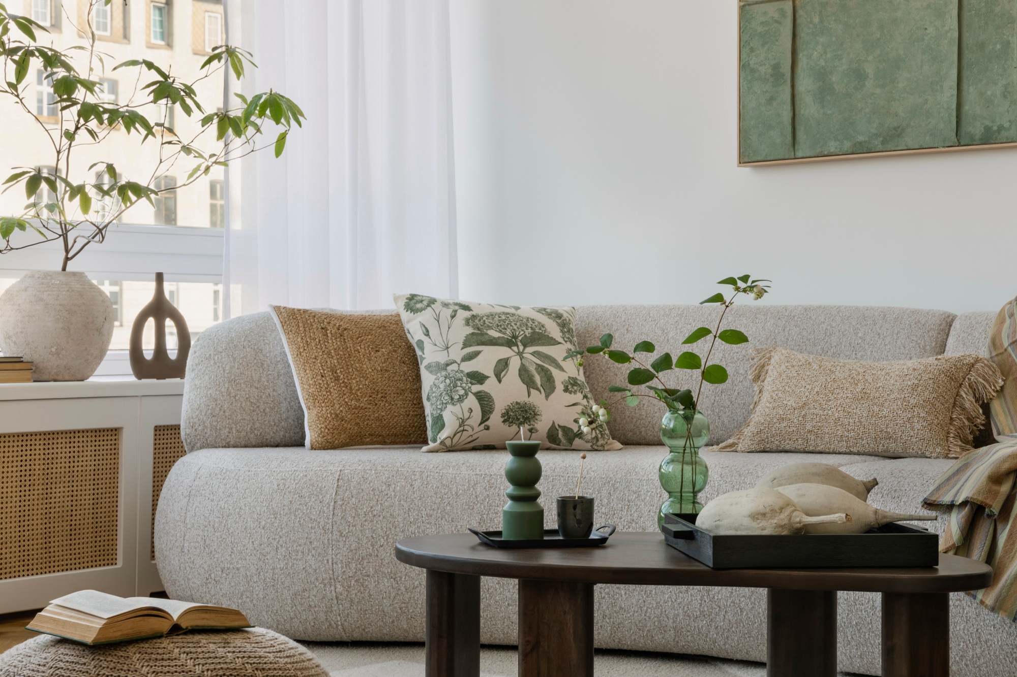 Inviting sofa setting with earthy pillows, green accents, and a rustic coffee table, perfect for cozy gatherings.