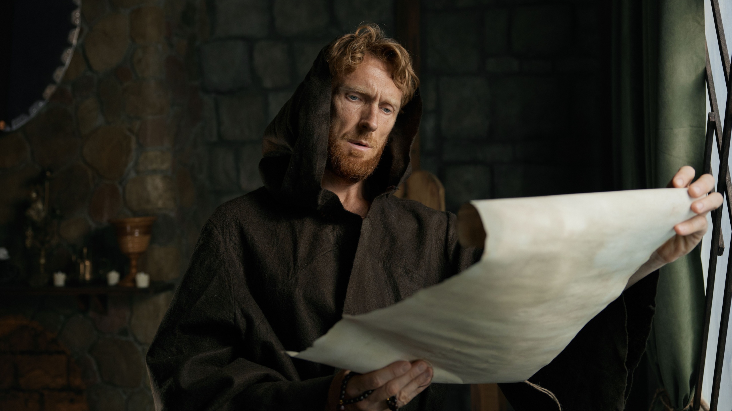 Medieval monk reading obsolete historical parchments and holy manuscripts