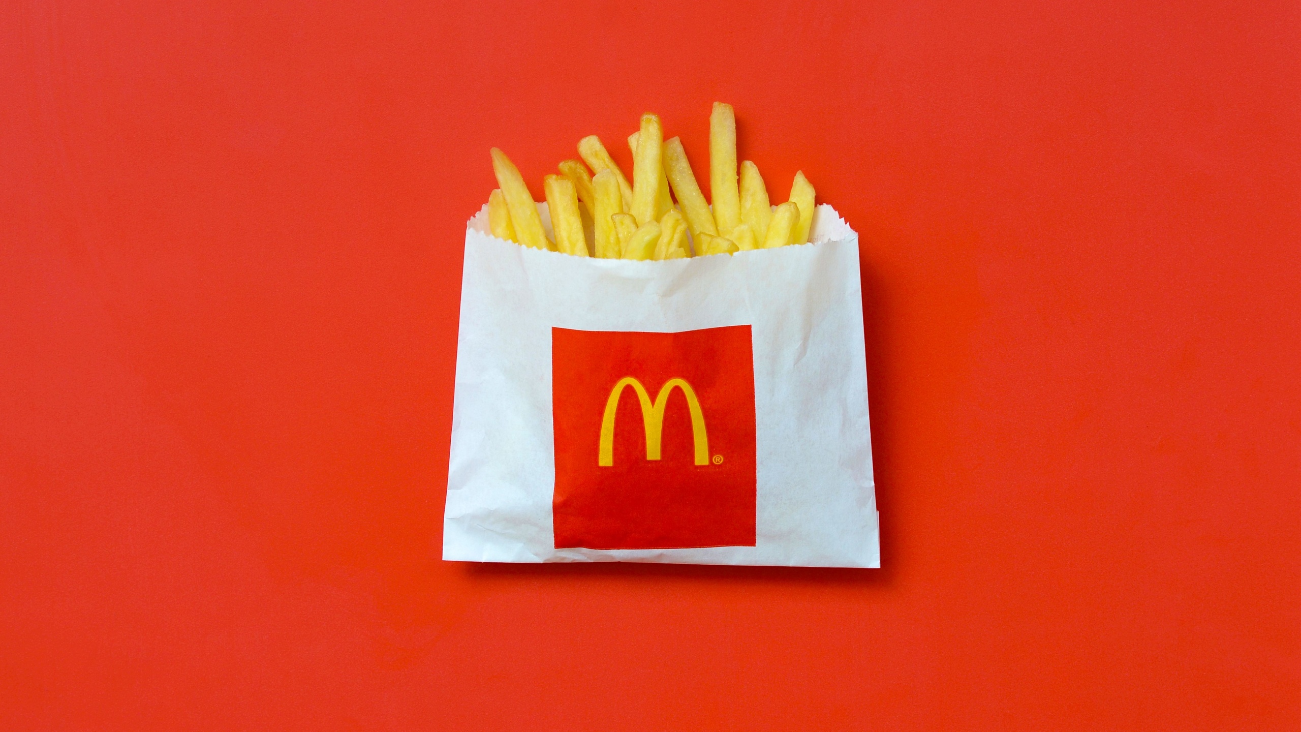 McDonald's French fries in small paperbag on bright red background