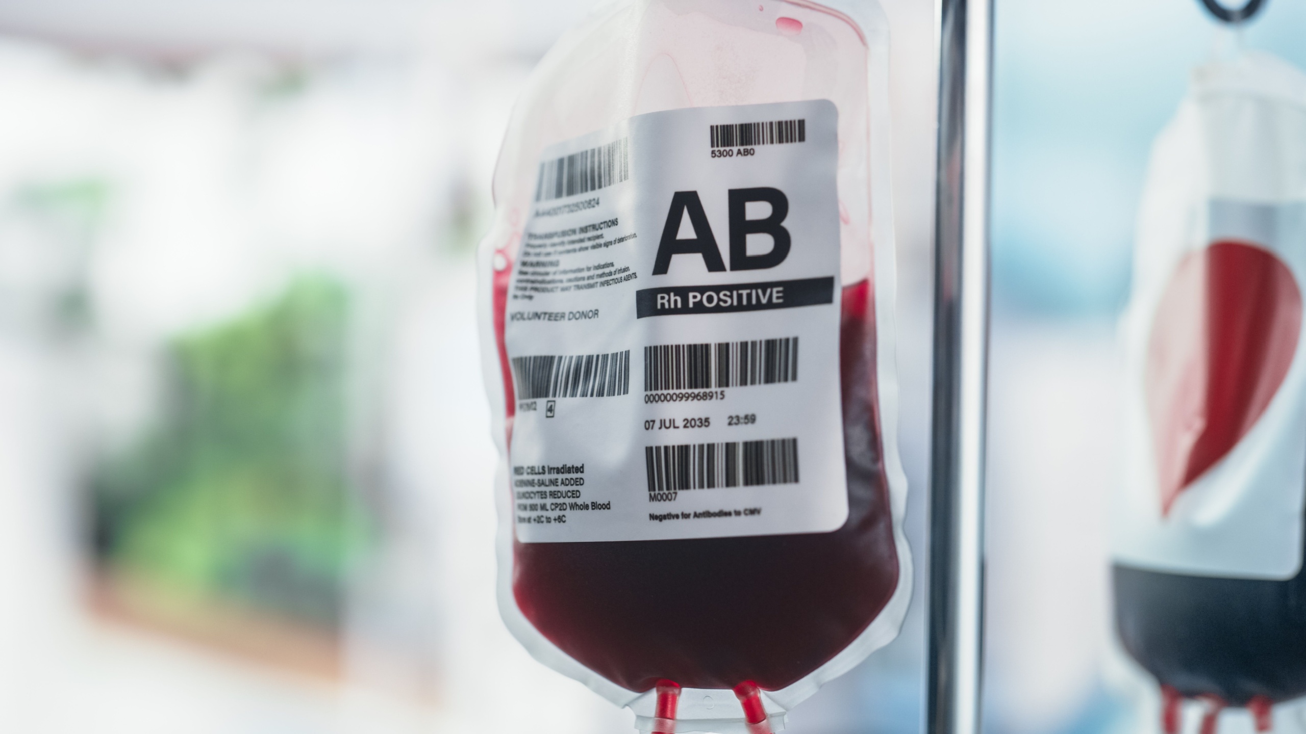 Close Up Shot Of Two Blood Bags From Donor Hanging On The Stand In Donation Center Or Hospital. Concept Of Saving Lives of Patients Who Require Blood Transfusion After Organ Transplantation.
