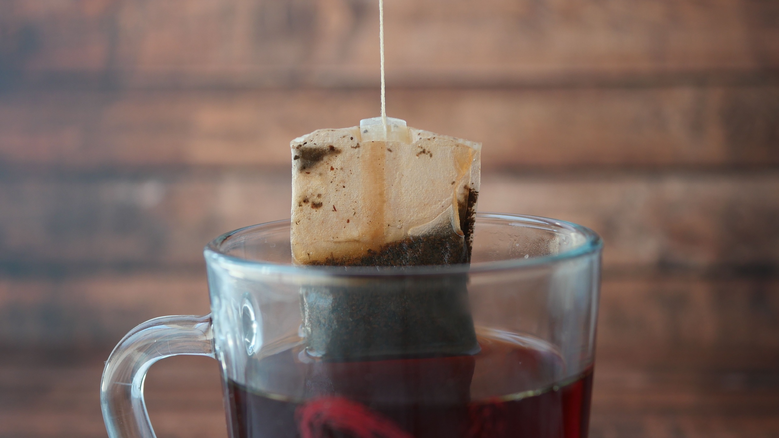 Green tea and tea bag on table, close up.