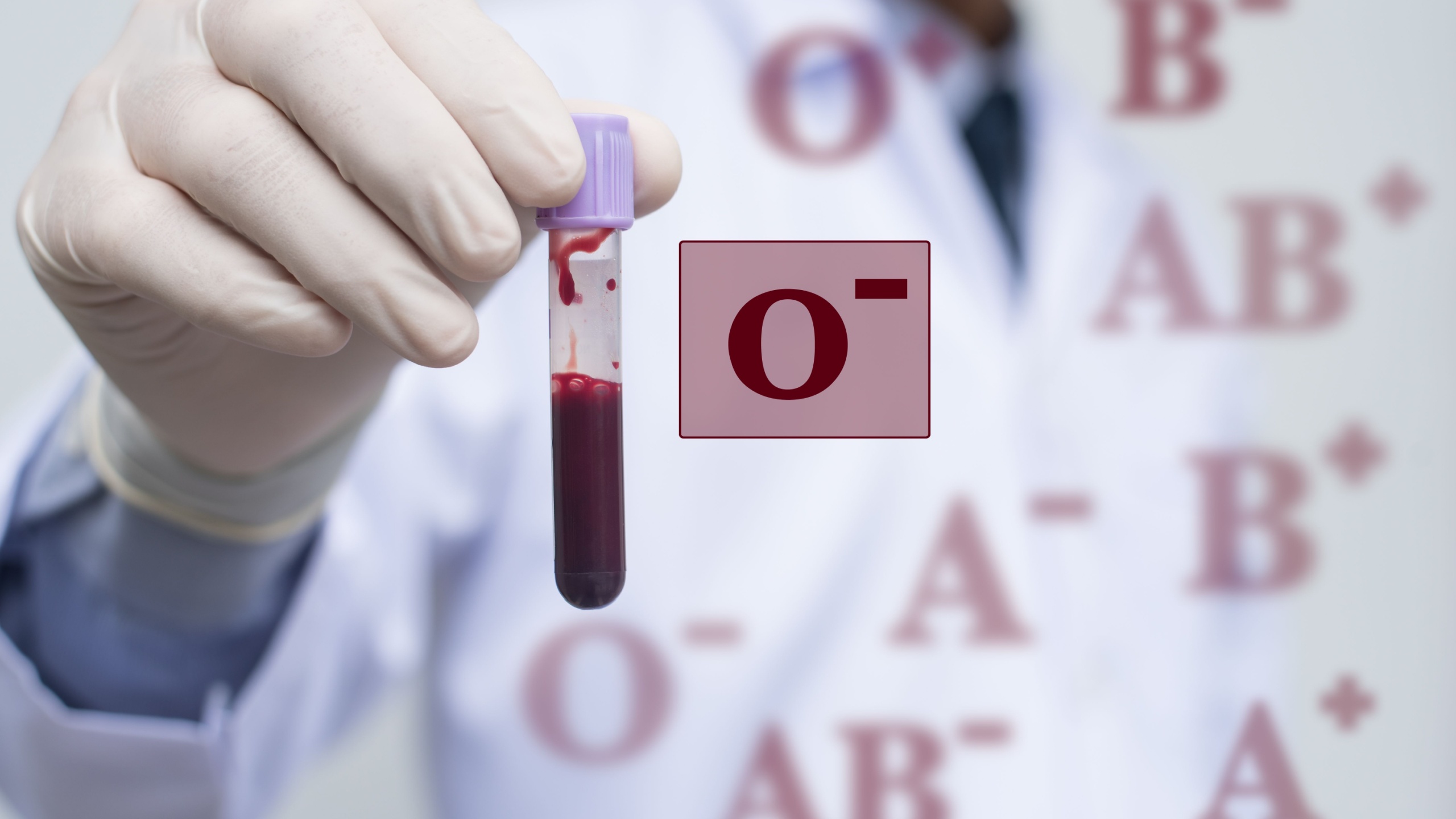 Male doctor or technician holding red blood (fresh whole blood) in test tube and blood group icon, blood group O Rh positive. Blood donation concept.