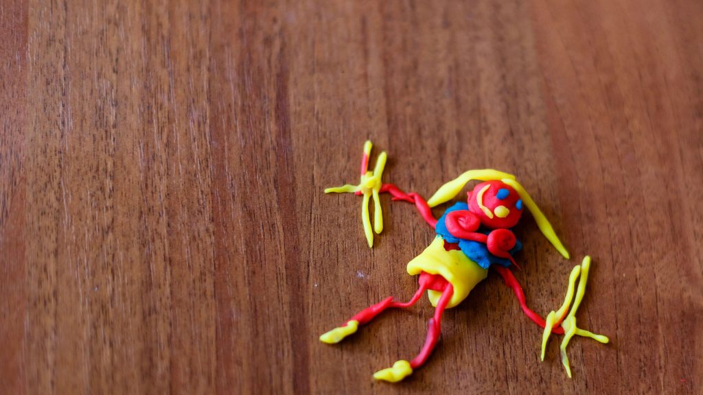 Doll from colorful clay dough plasticine made by child A doll of colored plasticine