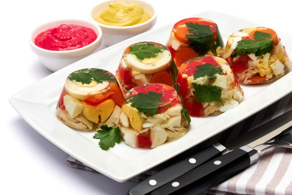 Portion of delicious chicken aspic on a plate isolated on white background