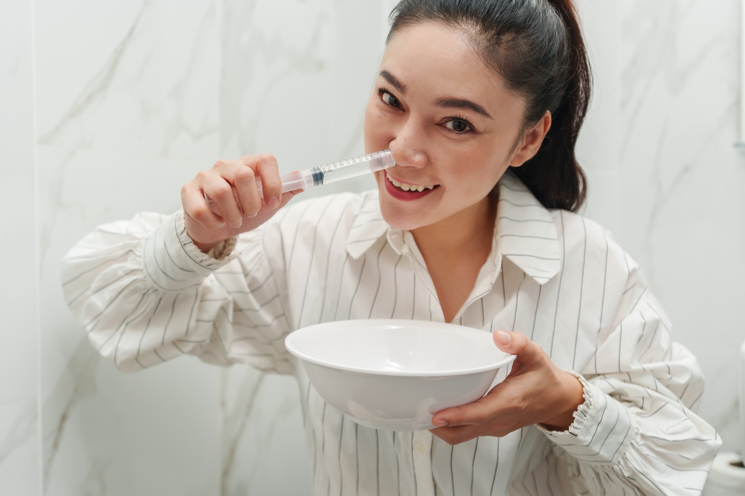 woman making nasal wash with using sryinge flushing inside her nose