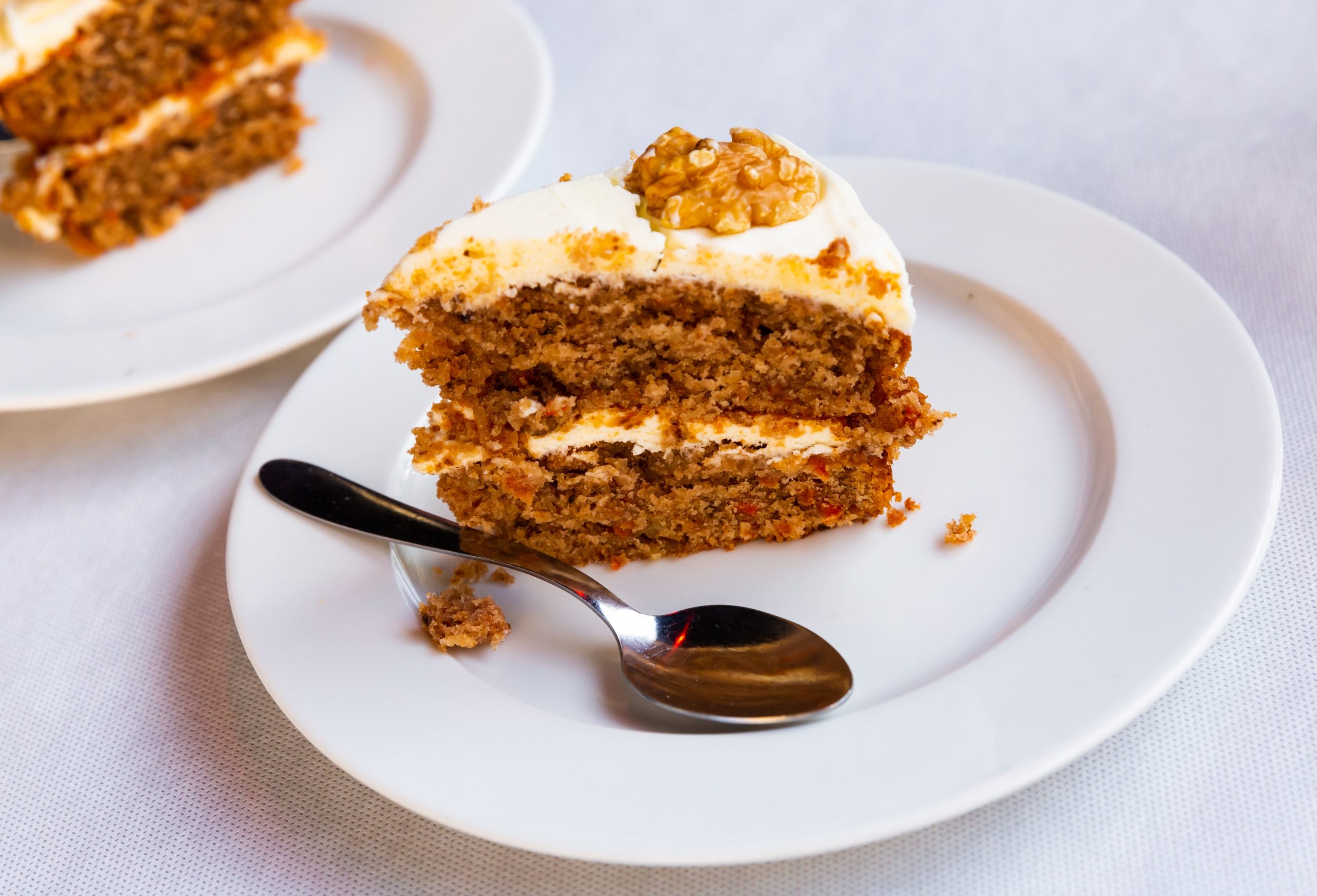 Tasty dessert, slice of fluffy carrot cake decorated with nuts
