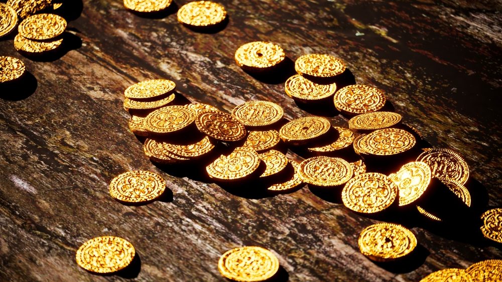 An array of lustrous gold coins spread out over a dark, aged wooden background, bathed in soft light that accentuates their rich textures and historic value.